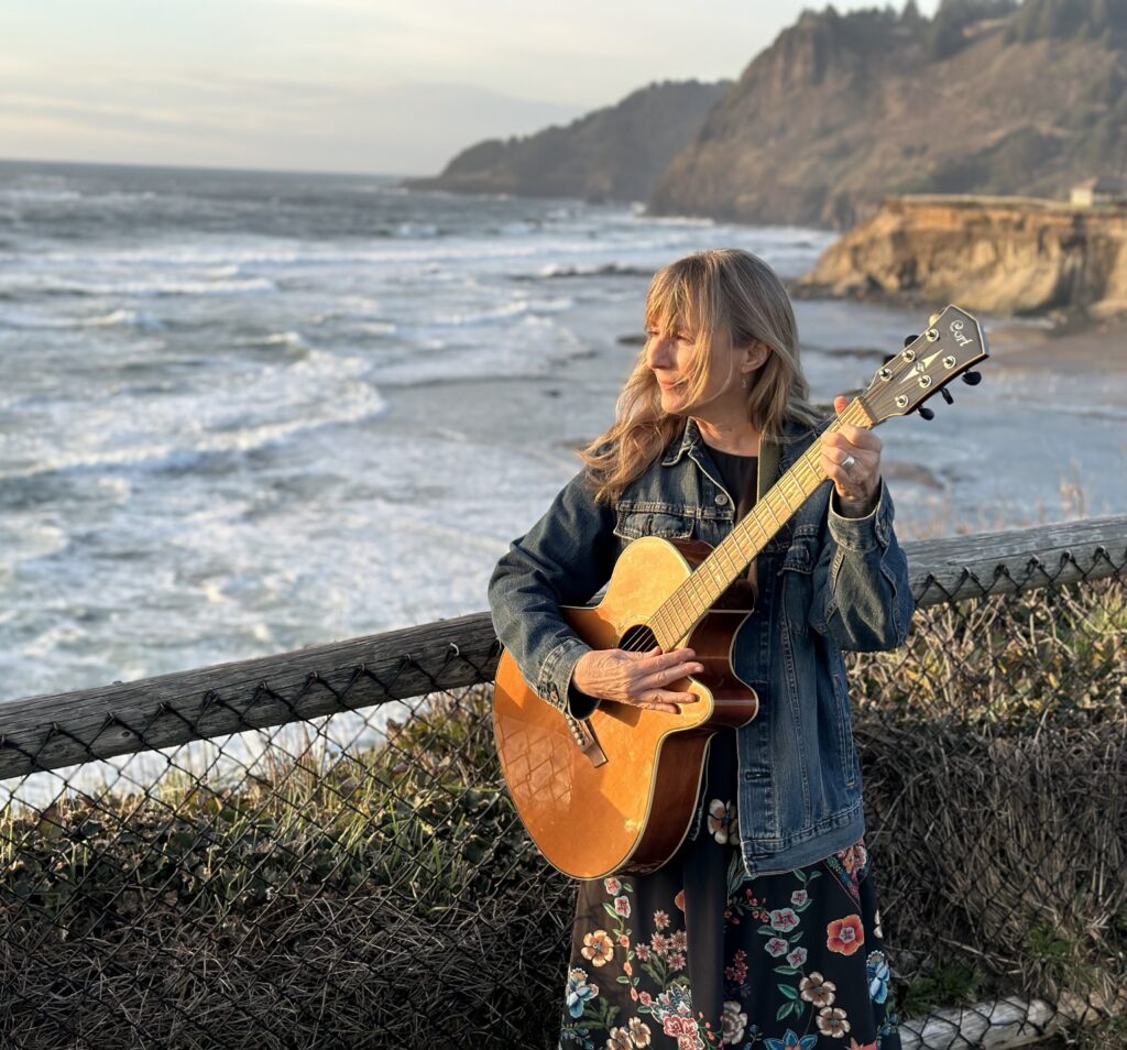 Linda by ocean with a guitar